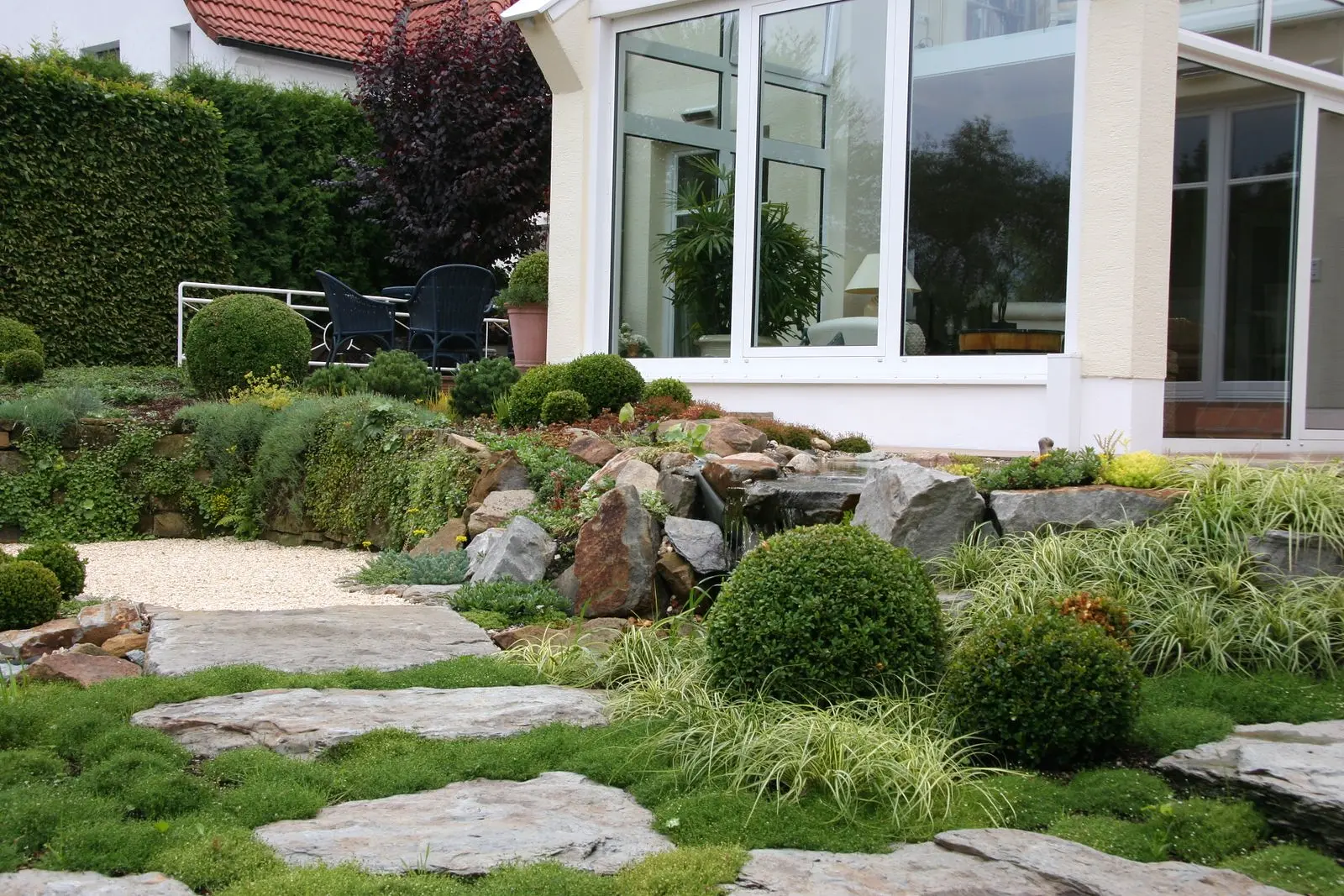 Gartenanlage am Wohnhaus mit Naturstein und Bepflanzung